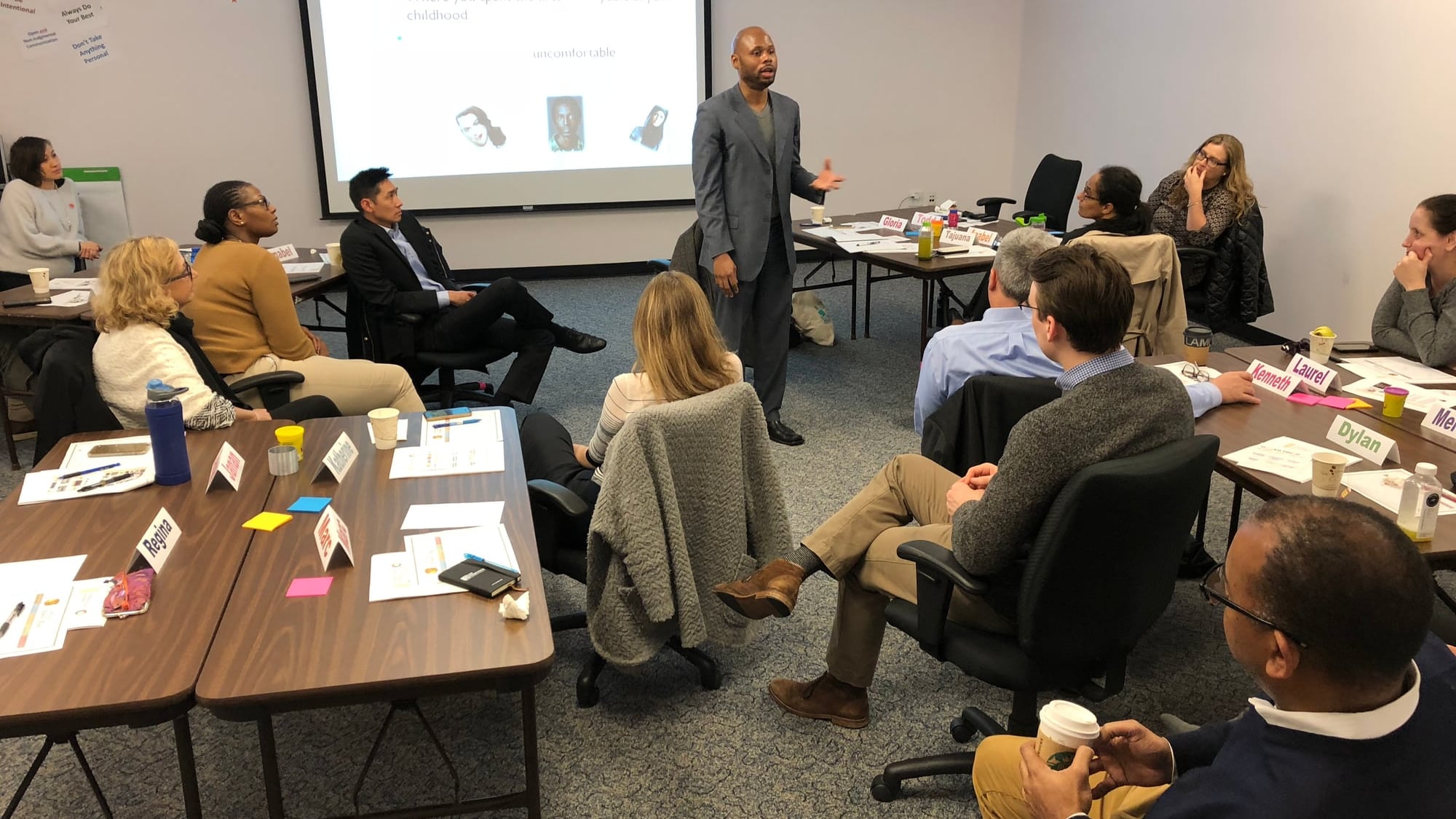 A small classroom training session with U-shape seating, Dante King teaching to leadership cohort.